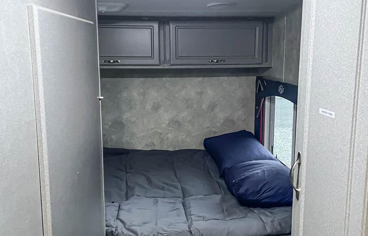 Front queen bed next to bathroom.