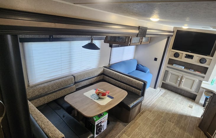 Living ,  Kitchen and dining area.  U shape dinette, couch  & TV.