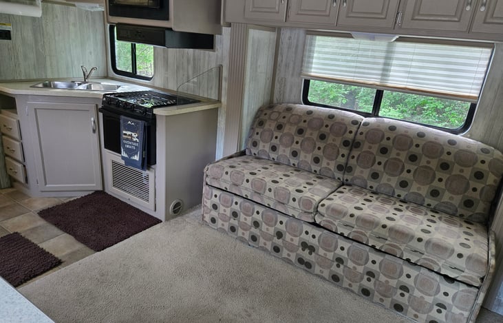 Kitchen has a microwave, range, and cooktop.  The couch pulls out into a bed.  The hot water gets HOT!!!  Be careful!