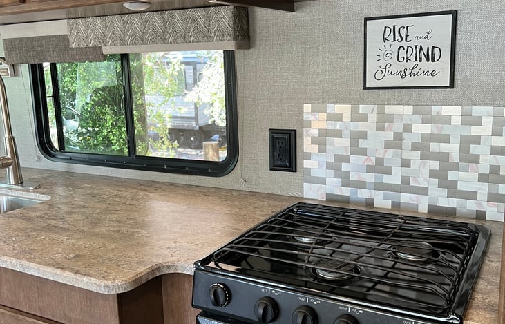 3 burner stovetop, microwave above, oven below. Plenty of counter space for prepping your meal.