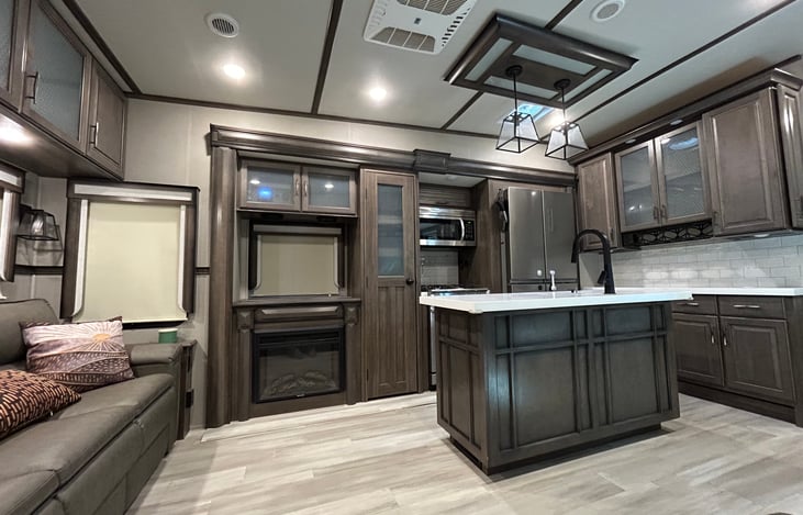 View of living room and kitchen from the recliners. Walk around island in the kitchen with high ceilings  makes this open floor plan feel huge!