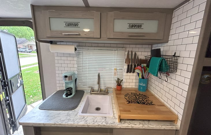 View of kitchen counter with stove cover and wall tiling.
