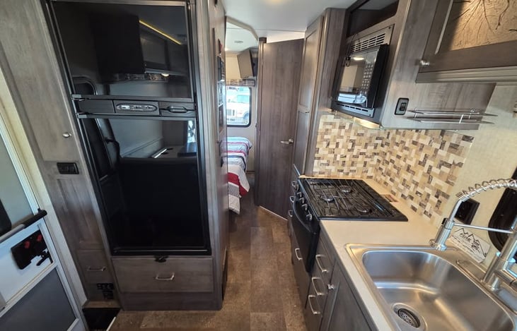 Full-size refrigerator, RV stove, oven, and microwave.