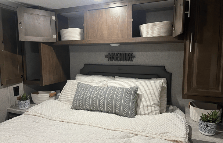 Closets with storage baskets above the bed to store clothes. Each side of the bed has baskets to keep organized.