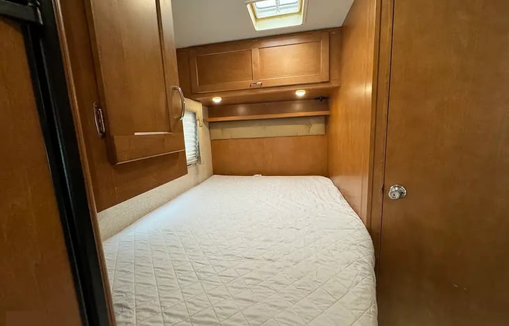 Bed in back includes privacy curtain, TV, cabinets, USB/120v plugs, fan and window.