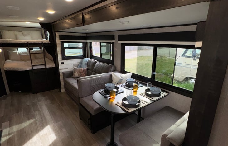 Full view of living area. Convertible dinette, pullout couch, and full sized bunk beds.