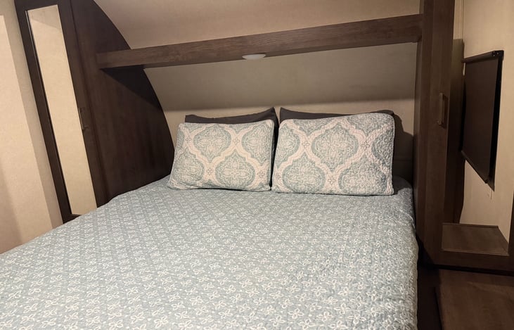 Master bedroom with queen bed and four pillows.