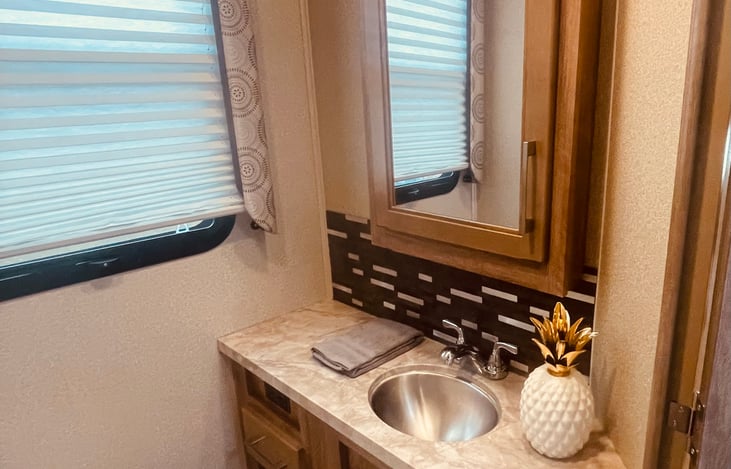 Stainless sink & faucets with vanity, decorative tile backsplash and large medicine cabinet.  Porcelin toilet