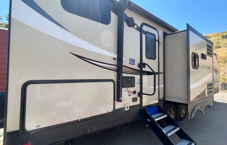 Kitchen tipout and rear door entry with stabilizing stairs. Outdoor kitchen is also located to the left of the door under the storage flap.