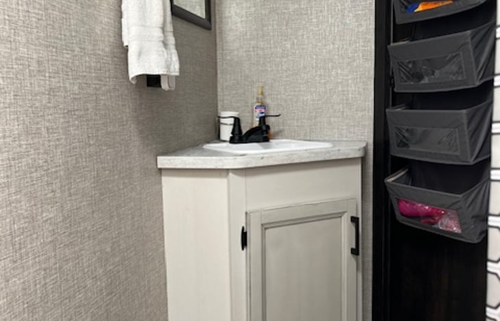 Bathroom vanity and door hanger to store additional supplies.