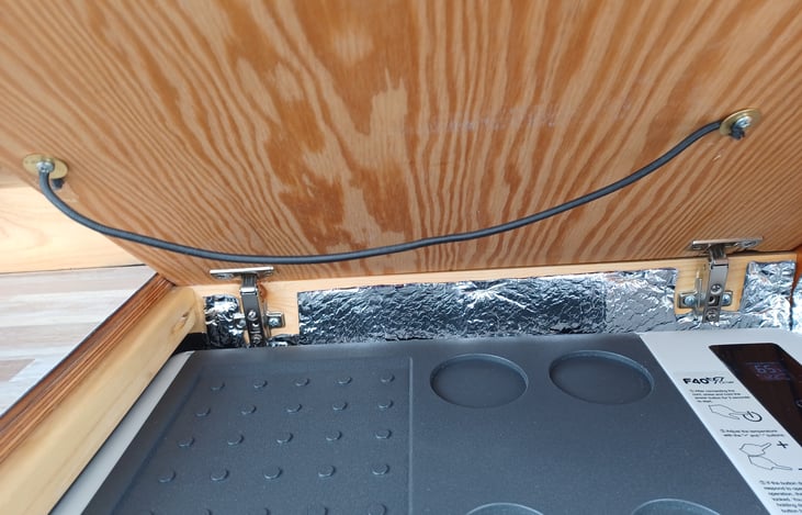 Fridge is under the left space counter in the galley.