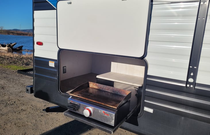 Outdoor cook top with storage located behind