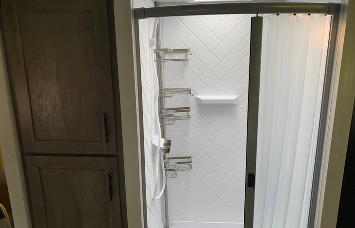 Large walk in radius soft shower. Cabinets for extra storage.