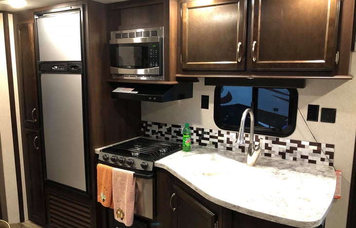 Kitchen, freezer, fridge, 3 burner stove and over, split sink.