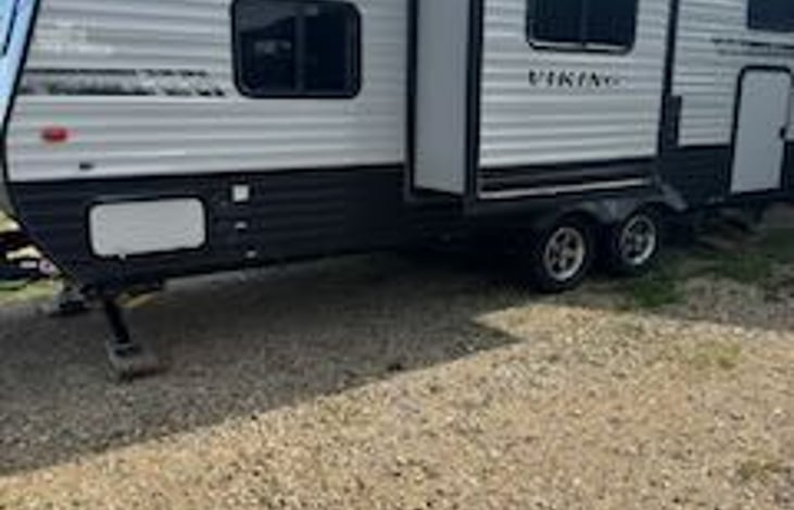 Has one slide out and under compartments for extra storage. Underneath includes a small grill for cookouts and an outdoor rug.