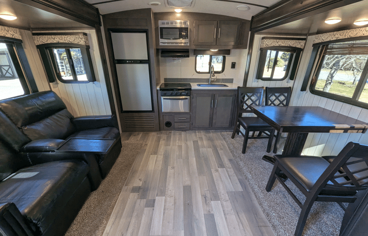 Very spacious living area offers a cozy retreat with theater-style recliners, a premium entertainment system, fireplace, TV, dinette and well-equipped kitchen.