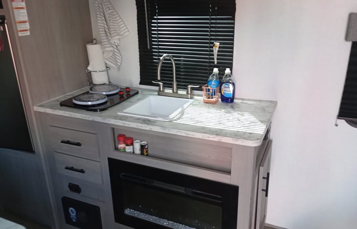 Kitchen with 2 gas burners and storage above. Window, fireplace, all dishes and pots and pans provided