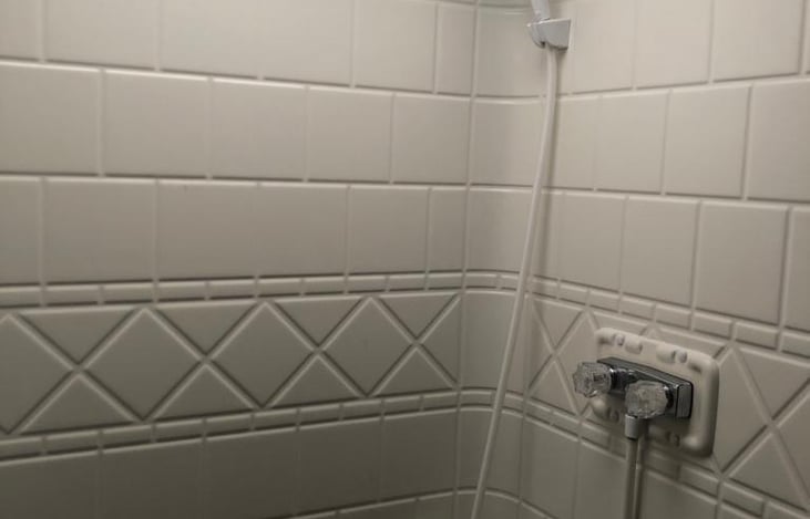 Spacious bathroom with shower, sink, toilet and extra cabinets for storage.