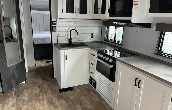 Abundant counter space in the main living area. Includes large sink, gas oven and 3 burner stove, microwave and gracious refrigerator with separate freezer compartment.