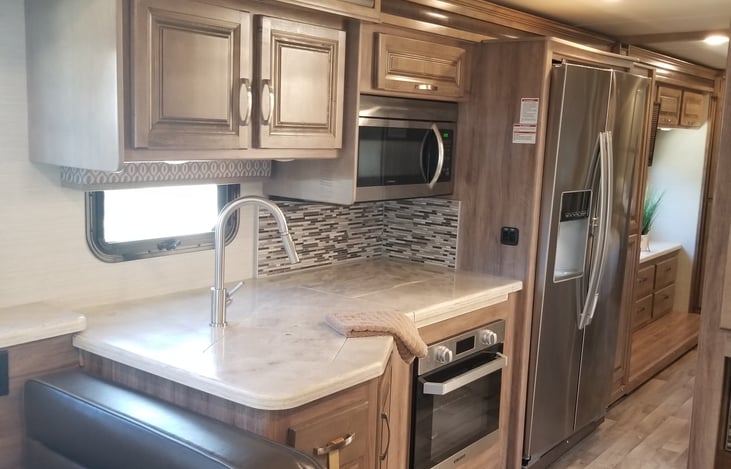 Kitchen with large sink, three burner stove, and oven also a Microwave convection oven compo.