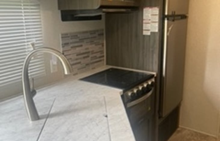 Kitchen Area (Fridge, Stove, Oven, Microwave) with sink cover for extra counter space when needed