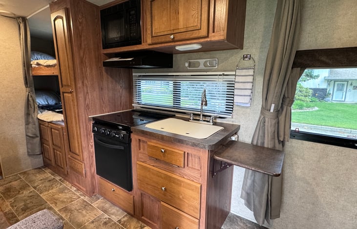 Kitchen with microwave (shore power or generator only), stove, cooktop and double sink