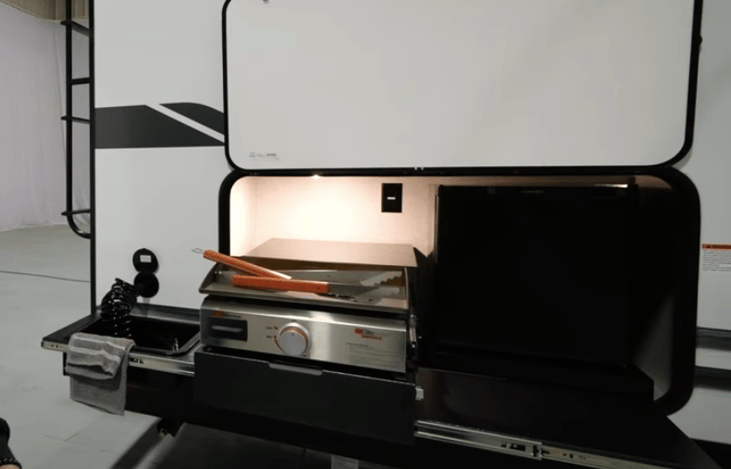 Outdoor Kitchen with Small Fridge, Griddle, Prep table, and Dump sink/basin