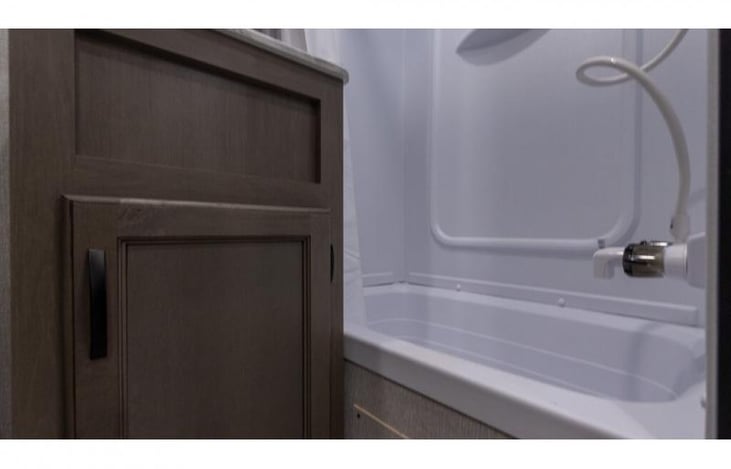 Second bathroom, cabinet with storage, bathtub and shower