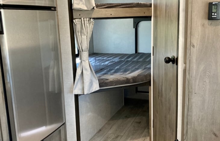 Oversized bunk beds, with storage under the lower bunk (which is accessible from a rear, exterior door).