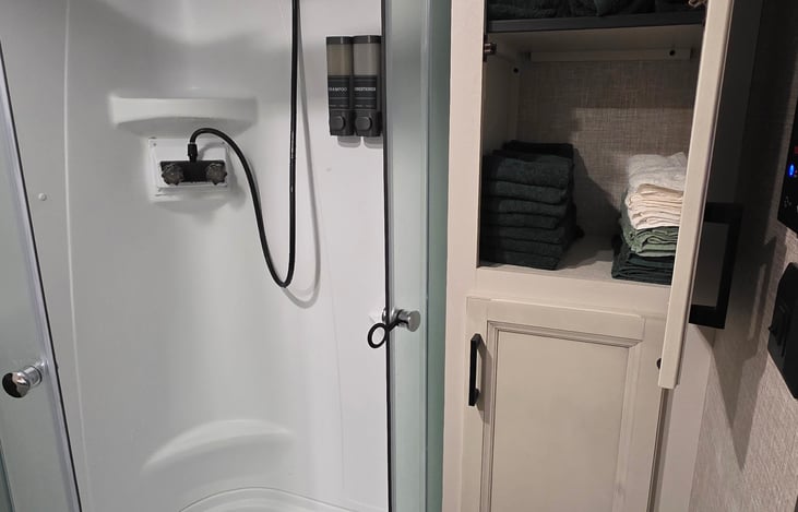 Shower soap dispenser come with booking as well as towels