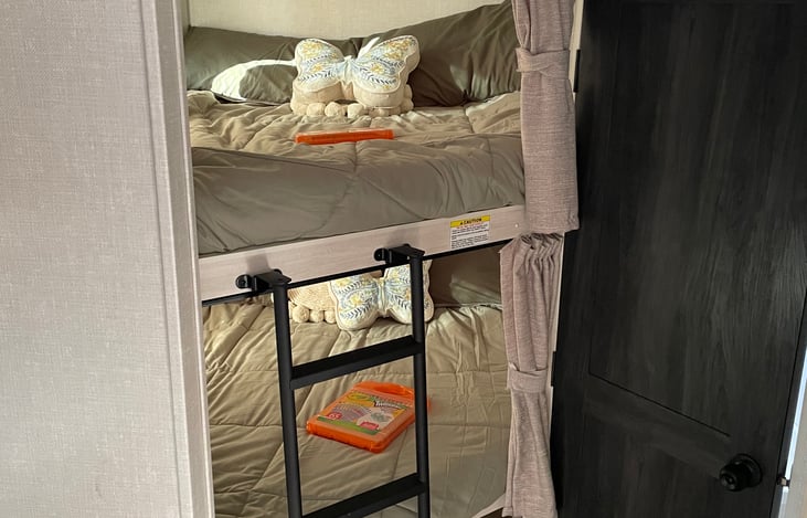 2 bunk beds each bunk has a 300 lb capacity. Bottom bunk folds up in half to access rear adventure door. Bunk ladder is removable by lifting up. There is USB ports in both bunks for accessory charging