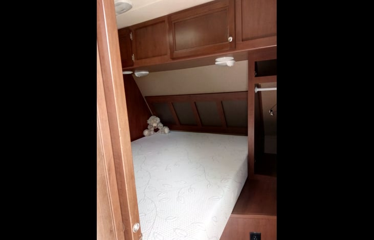 Queen bed with lots of storage above and below.