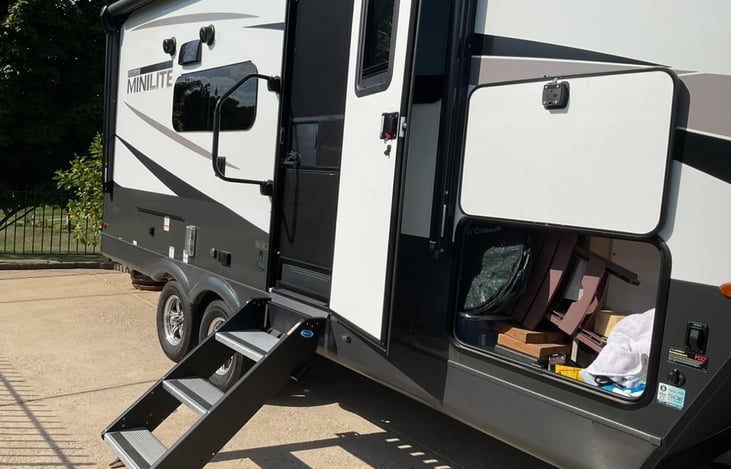 pass through storage, folding camp chairs, tool box, out door camp mat, broom & dustpan, swifer mop, air compressor, collapsible 5 gal drink water jug. collapsible 2.5 gal wash bucket