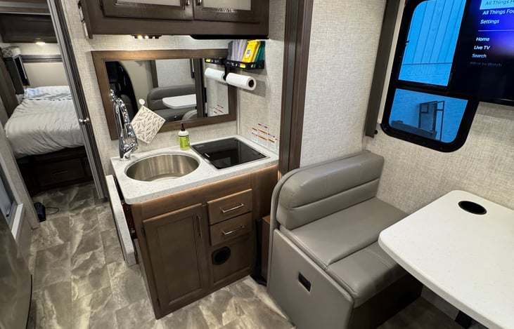 Cabinets above(dishes stored here, as well as knife set, cutting boards) and below(pots and pans here). Drawers with essential kitchen tools stocked(tongs, oven mitt, whisk, measuring cups).