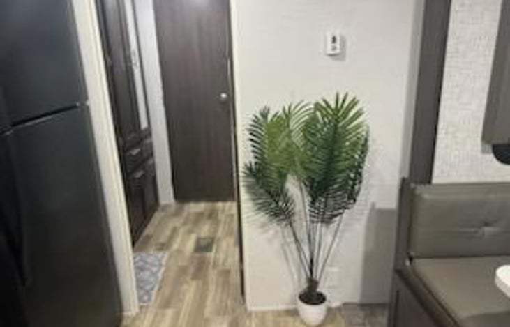 Walkway area leading to full bathroom. Storage area on left hand side under sink as well as cabinets.