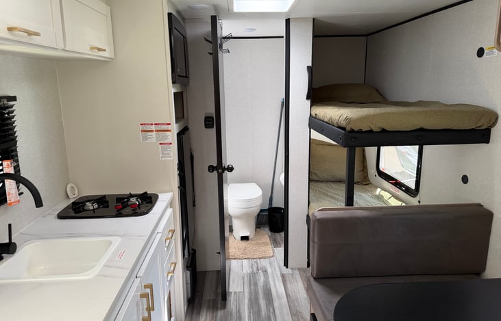 Kitchen, convertible dinette, bunk beds, and bathroom.