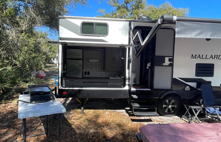 Outdoor kitchen with refrigerator, sink, in storage cabinet