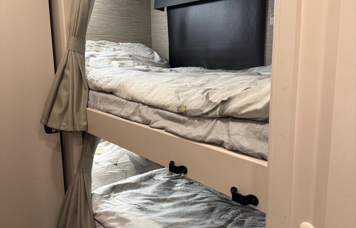 Twin bunk beds with privacy curtains, outlets and lights.