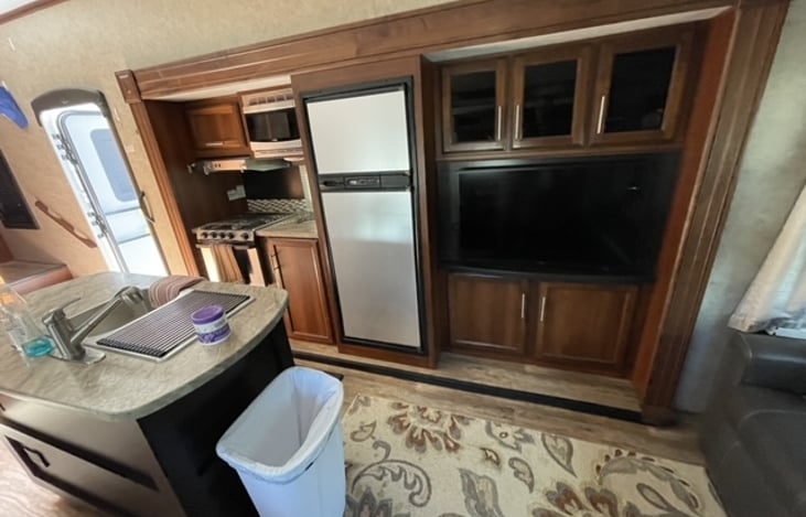 View of entry, kitchen and living room TV.