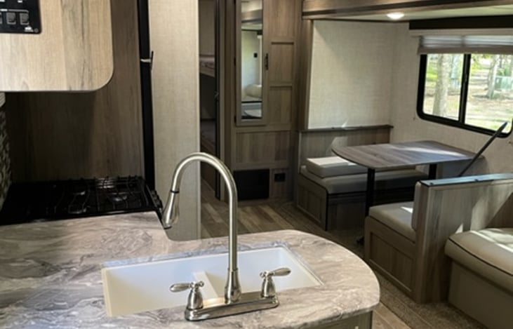 Nice sized dinette with cushions that is convertible to a bed. Full size mirror on the front of the pantry.