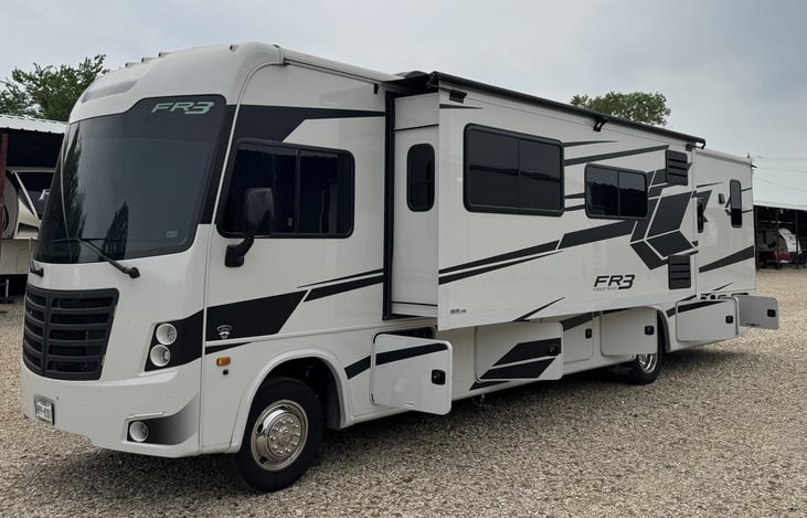 Driver side exterior with slide open and bays open.