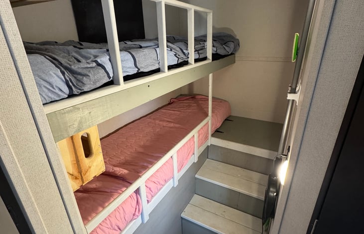 Bunk beds with convenient stairs for littles to go to the bathroom in the middle of the night, and railing so nobody falls out of bed!