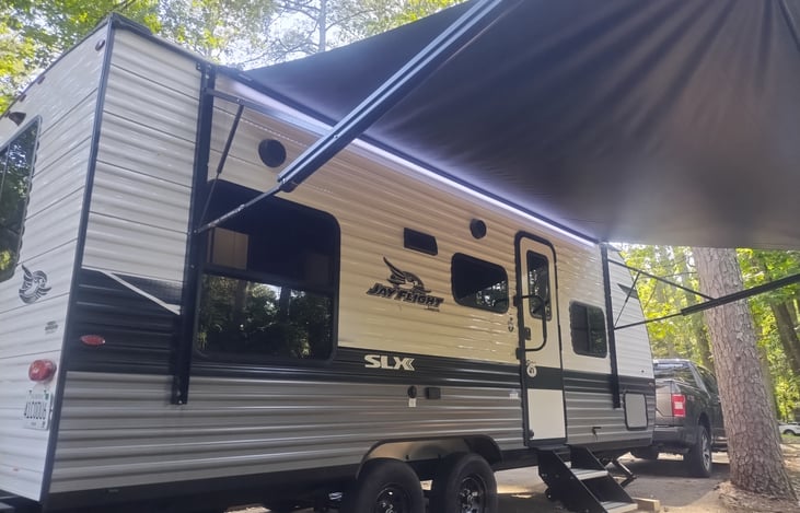 Side view of the camper set up at a campsite.