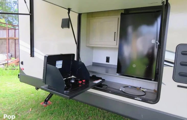 Outside kitchen with fridge, stove and grill