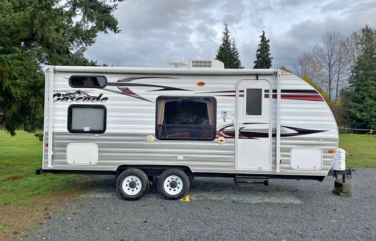 Manuel awning for shade or rain, electrical outlet when plugged into shore power, exterior stereo speakers, 2 storage compartments