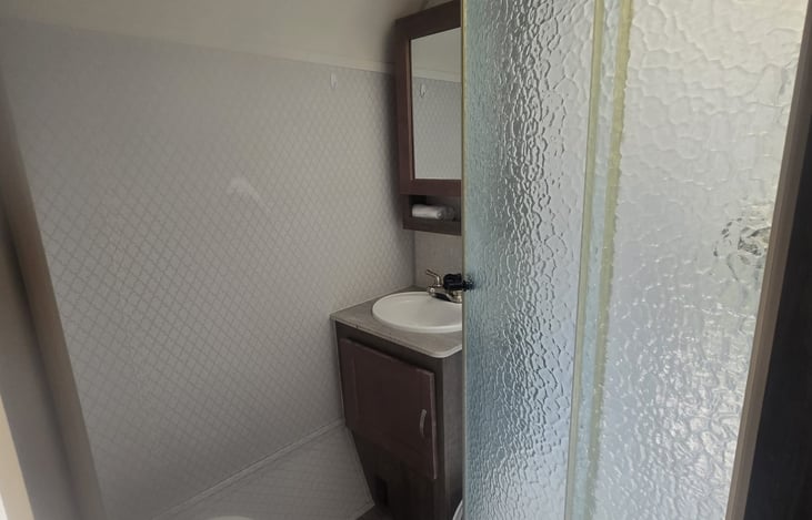 bathroom sink and cabinet stocked with necessities