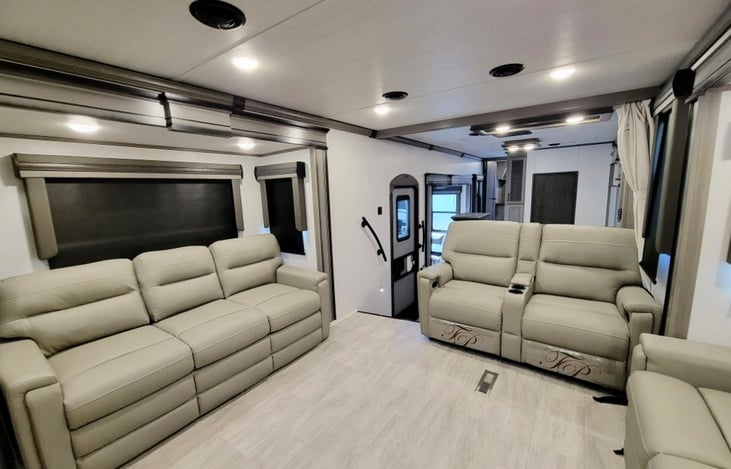 Spacious and luxurious elevated Front Living Suite with opposing slide-outs that create a massive theater-style room separate from the kitchen. 3 couches, warm fireplace and large flat-screen TV make