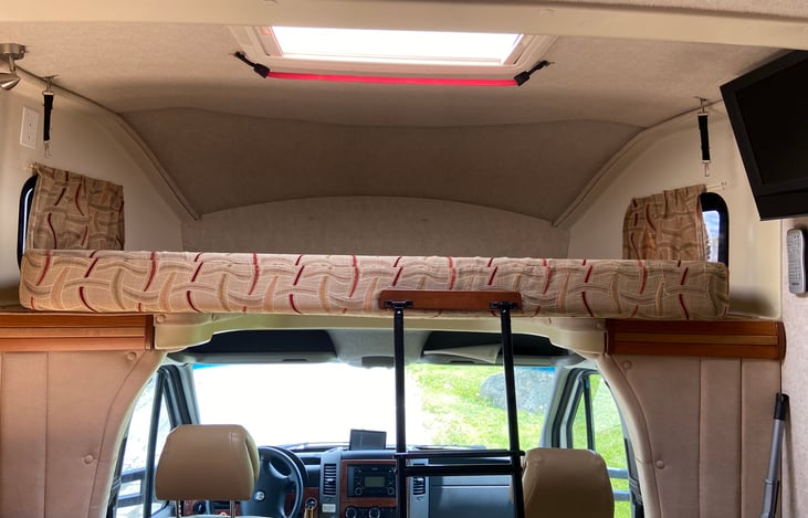 The bed lifts up and is secured by two hooks when not in use. Awesome skylight also featured!