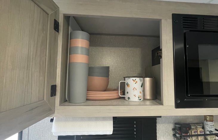 Stocked with plates, bowls, cups, coffee mugs, Keurig coffee maker, pots & pans, and all kitchen utensils. Flat top griddle for outside cooking as well.