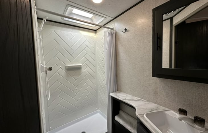 Nice size bathroom with toliet, sink and storage.